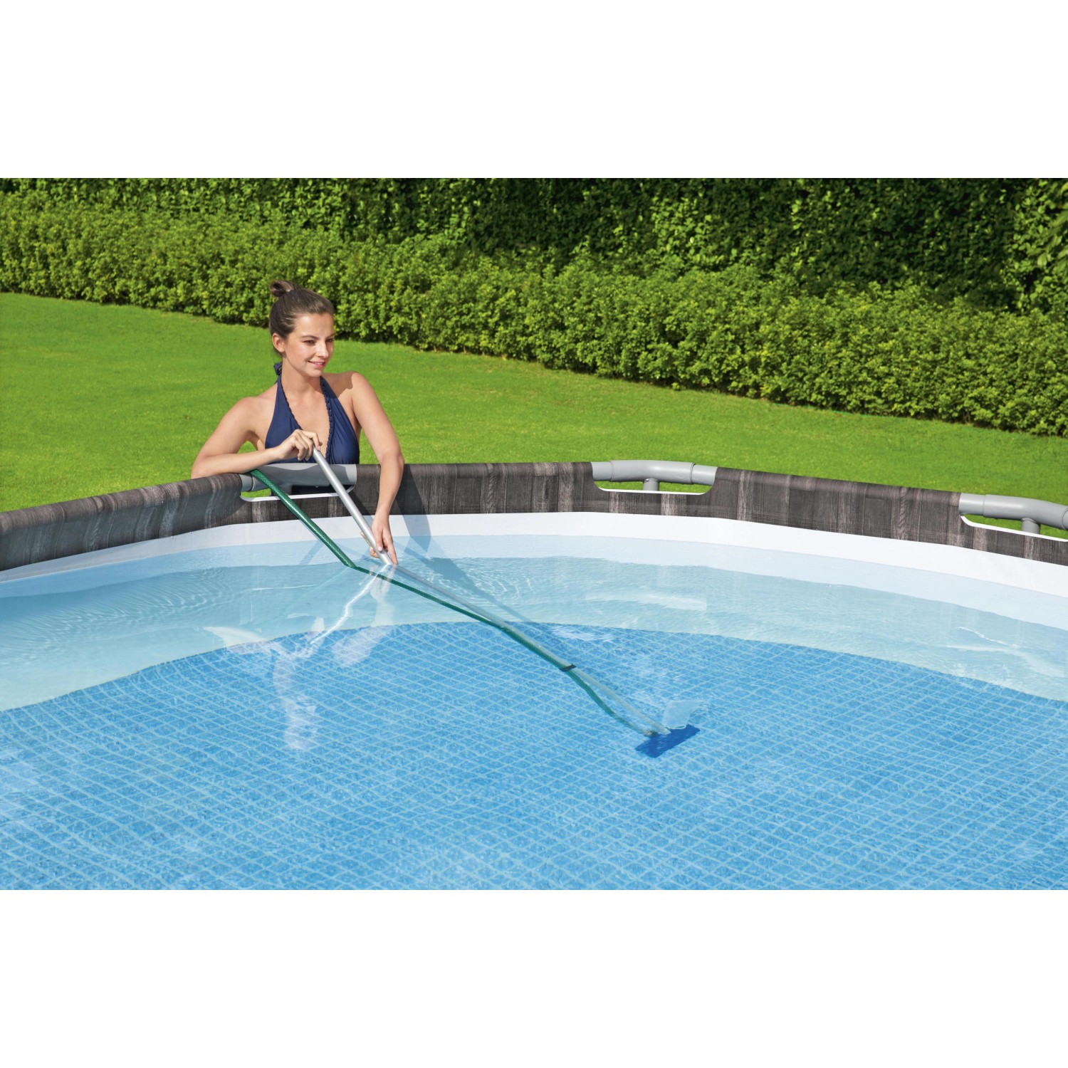 Frau reinigt Pool mit Bestway Reinigungsset, bestehend aus Kescher und Sauger mit Stiel.