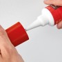 Anwendung von Fischer Dicht Kleber 80ml: Tube, Düse und roter Deckel in Händen.