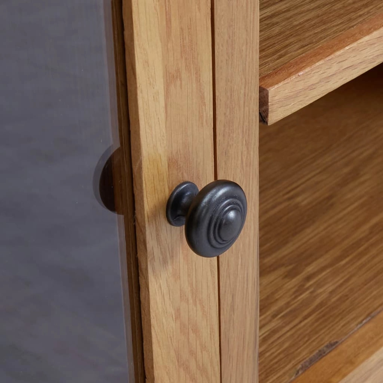 Detailaufnahme: TV-Schrank aus Eiche mit Tür und schwarzem Knopf.