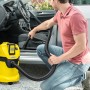 Gelber Kärcher Akku-Mehrzwecksauger WD 3 Battery beim Reinigen eines Autoinnenraums.
