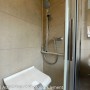 Beige Grosfillex GX Wall+ Creme Slate Dekor-Paneele in Dusche mit Sitz und Armatur.