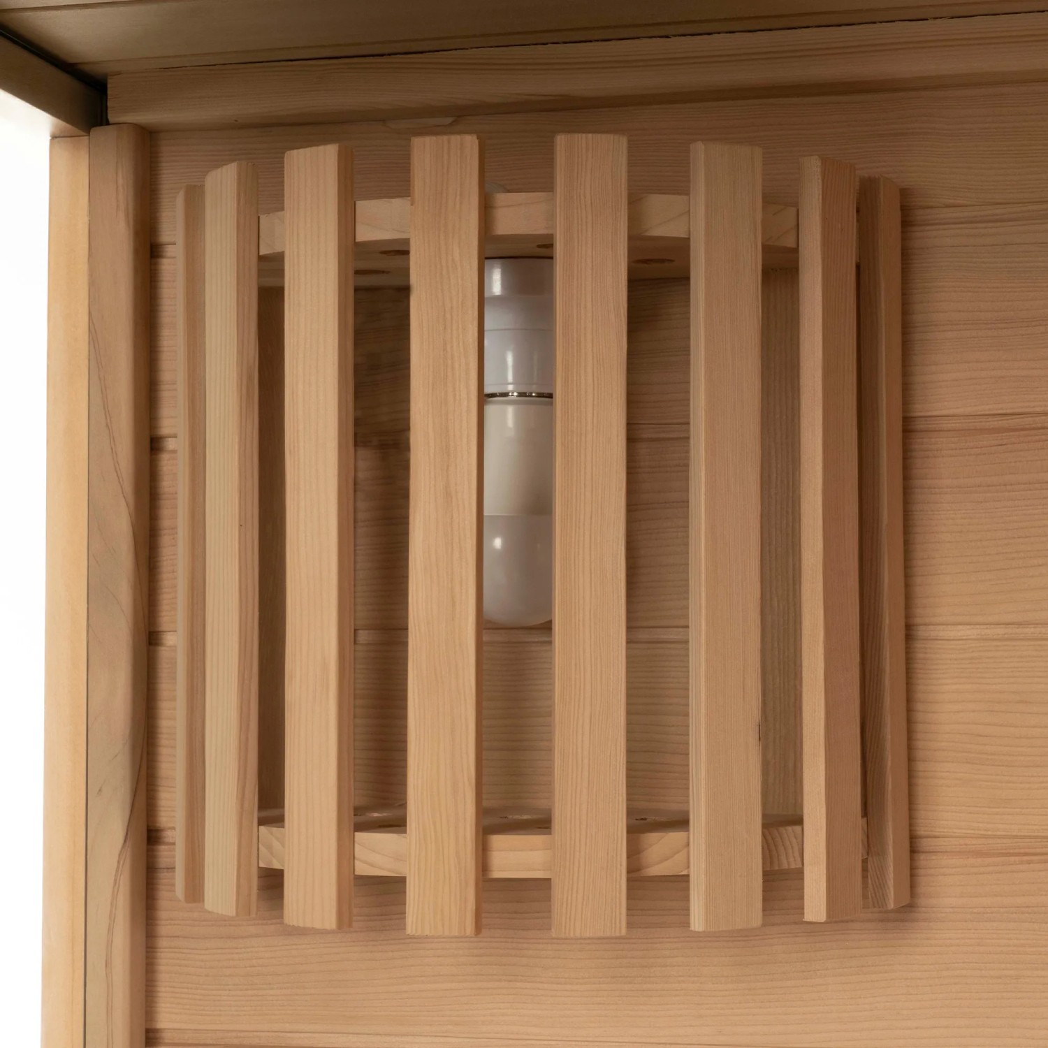 Detailaufnahme der Saunaleuchte hinter Holzverkleidung in der SKYLINE BIG Sauna aus Tannenholz.
