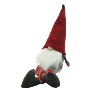 Weihnachtlicher Wichtel aus Filz mit roter Mütze und Baumelbeinen als Dekoration.