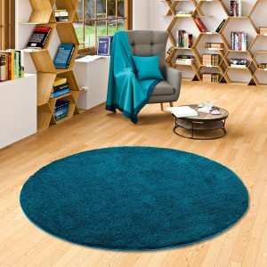 Runder, petrolfarbener Hochflor-Teppich (100x100cm) der Marke Snapstyle Palace im Wohnzimmer.