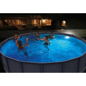 Szene mit LED Poolbeleuchtung in rundem Pool mit badenden Personen bei Nacht.