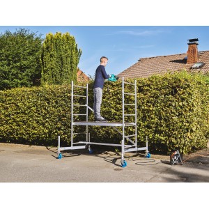 Krause ClimTec Grundgerüst mit Person beim Heckenschneiden, Arbeitshöhe 3 m.