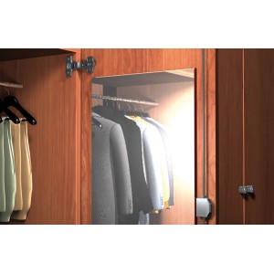 Kleiderschrank mit Kleidung und Beleuchtung, Holztüren und Metallbeschlägen.