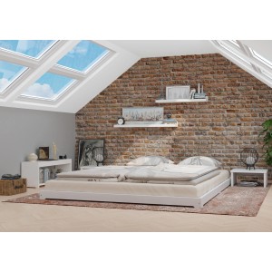 Weißes, flaches Doppelbett (160x200) aus Massivholz im Schlafzimmer mit Ziegelwand.