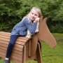 Mädchen auf roba Spielpferd Sheddie aus Teakholz. Robustes Voltigierpferd für den Garten.
