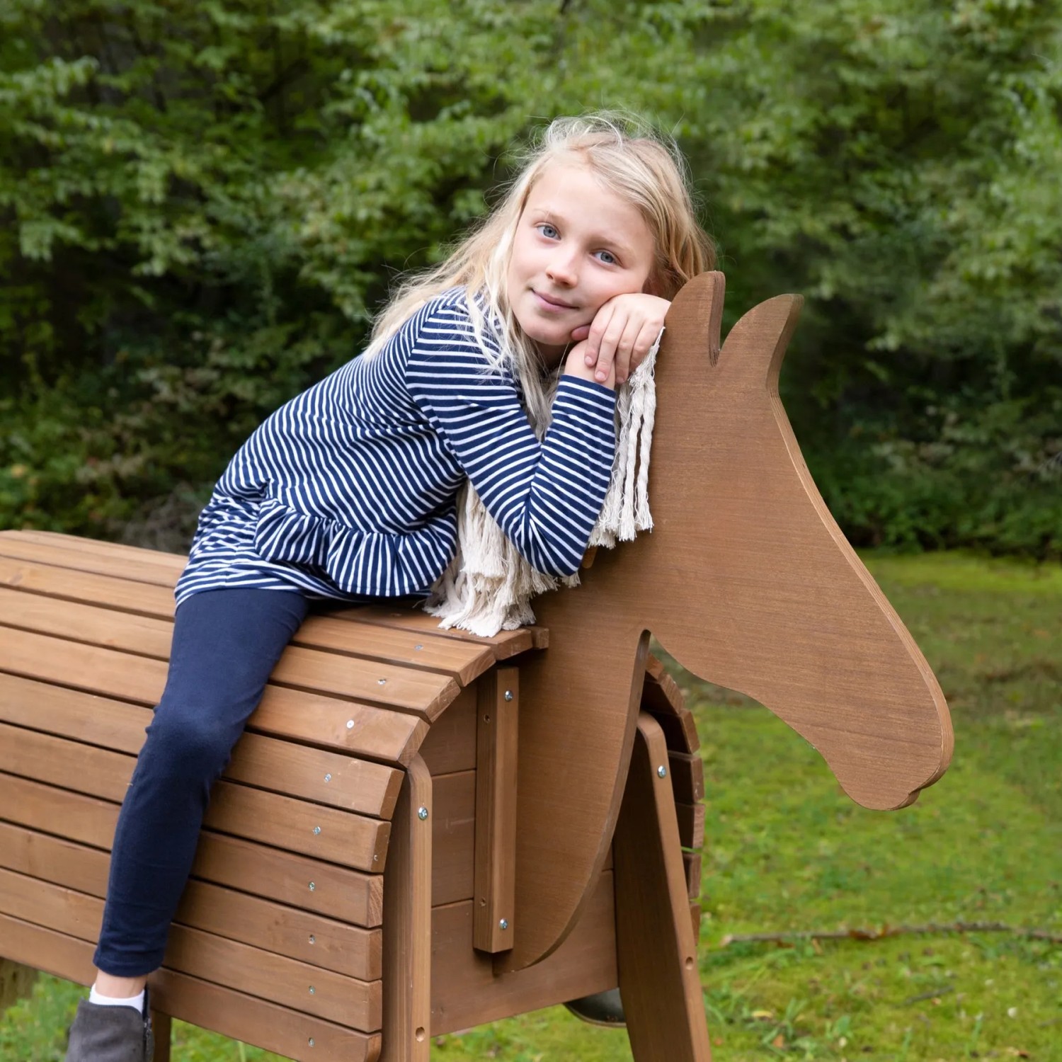 Mädchen auf roba Spielpferd Sheddie aus Teakholz. Robustes Voltigierpferd für den Garten.