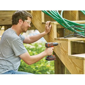 Mann bohrt mit Black+Decker Akku-Bohrschrauber BDCDC18 in Holztreppe. Inkl. Akku.