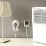 Energiekostenmessgerät mit Monitor zwischen Steckdose und Gerät zur Verbrauchsanalyse.