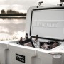 Offene, sandfarbene Petromax Kühlbox 50L mit Getränken und Lebensmitteln. Ideal für Camping.