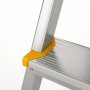 Detailaufnahme: Silberne Aluminium-Stufenstehleiter mit gelbem Anti-Rutsch-Fuß.