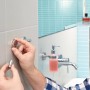 Montage eines Tesa Handtuchhakens Moon in Edelstahloptik im Badezimmer.