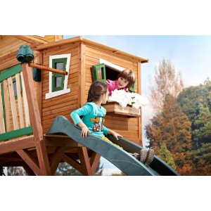 Spielhaus mit Blumenkasten und Kindern am Fenster und auf der Rutsche.