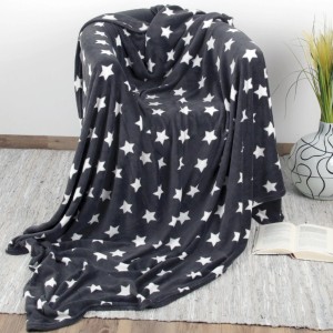 Anthrazitfarbene Kuscheldecke mit weißen Sternen auf einem Sessel. Flauschige Wohndecke 180x220 cm.