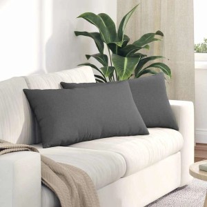 Zwei dunkelgraue Sofakissen aus Stoff auf weißem Sofa. Rechteckige Kissen 80x40 cm für Wohnzimmer.