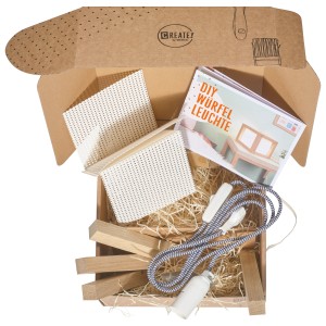 CREATE! by OBI DIY Würfelleuchte Bausatz in geöffneter Box mit Anleitung, Leuchtmittel und Holzteilen.