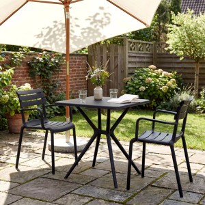 DELUKE Gartenmöbel-Set NORA: schwarzer Kunststofftisch und 2 stapelbare Stühle auf Terrasse, ideal für Balkon.