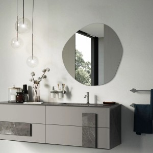 Moderner, unförmiger Tulup Wandspiegel über einem Badwaschtisch. Spiegelt Fenster und Bäume wider. Ideal für Bad, Flur, Schlafzimmer.