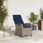 Grauer Poly Rattan Gartensessel mit verstellbarer Rückenlehne und marineblauen Kissen, dazu passender Beistelltisch auf Terrasse.