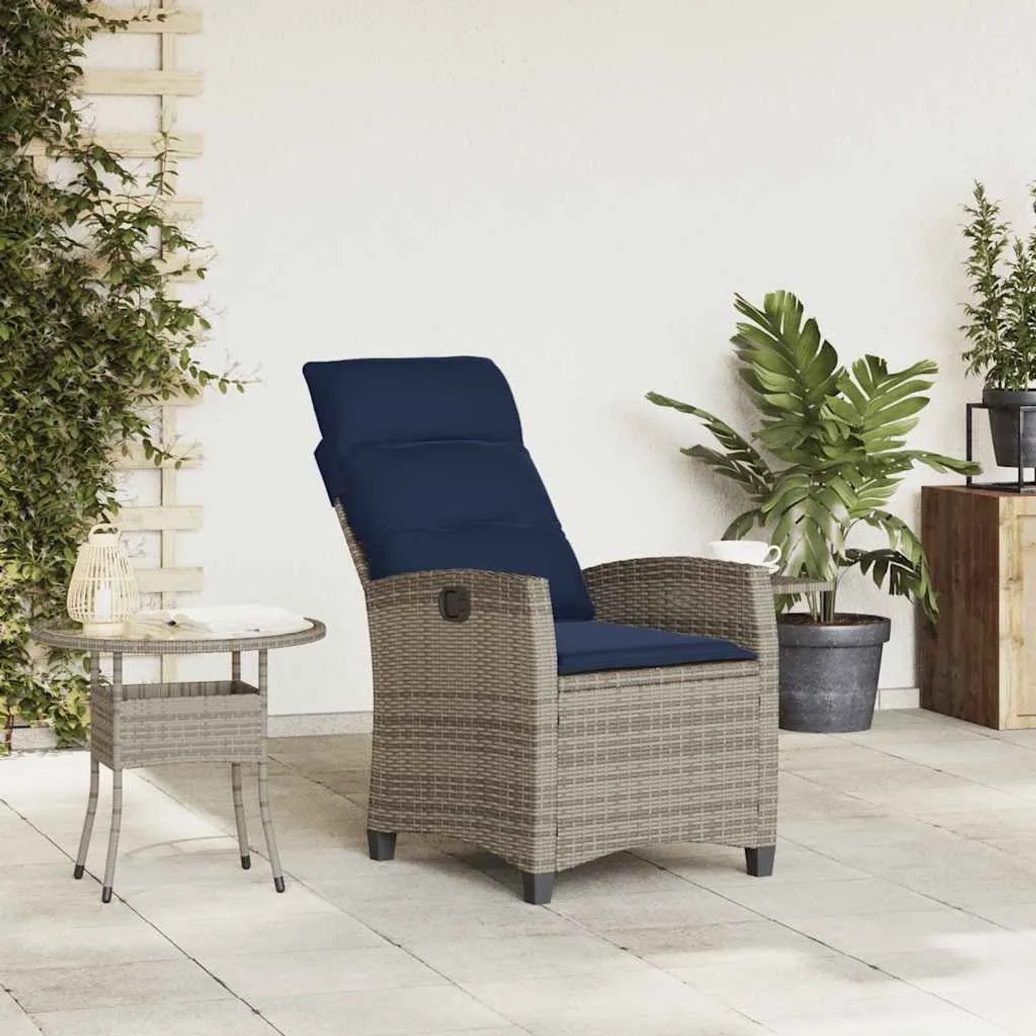 Grauer Poly Rattan Gartensessel mit verstellbarer Rückenlehne und marineblauen Kissen, dazu passender Beistelltisch auf Terrasse.