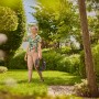 Frau trägt Gardena Gartenschlauch-Set Liano™ Life 10 m durch den Garten.