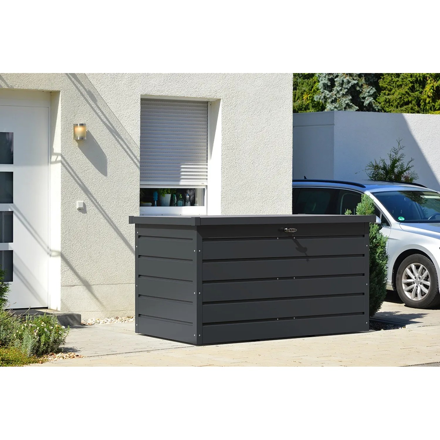 Duramax Metall-Gerätebox Palladium in Anthrazit vor Hauswand. Wetterfeste Aufbewahrungsbox für Gartenutensilien.