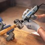 Dremel 4250 Multifunktionswerkzeug beim Gravieren eines Hammers in Werkbank eingespannt.