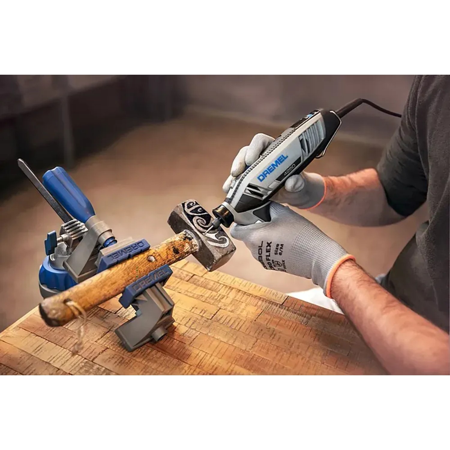 Dremel 4250 Multifunktionswerkzeug beim Gravieren eines Hammers in Werkbank eingespannt.