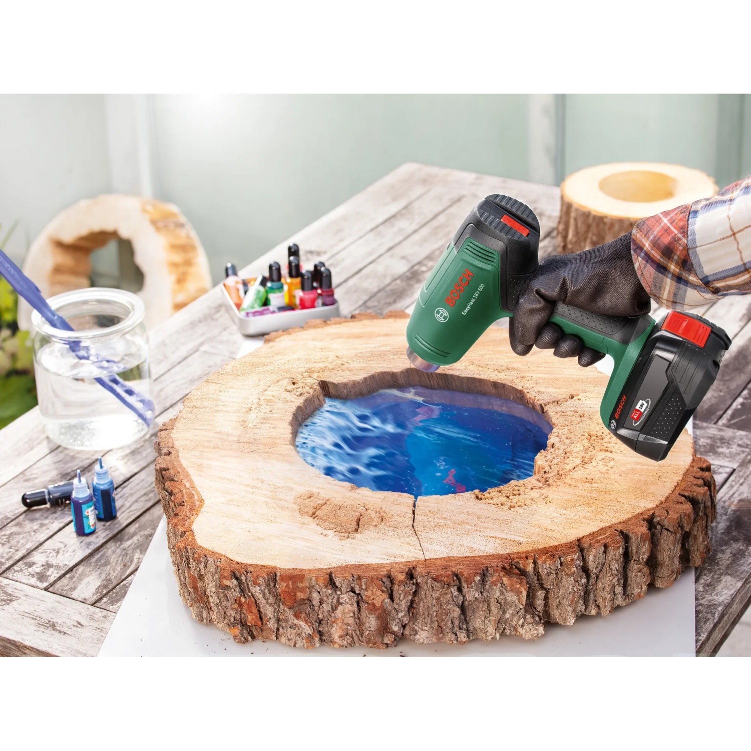Bosch Akku-Heißluftgebläse EasyHeat 18V-500 beim Bearbeiten eines Holzstücks mit Epoxidharz.