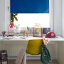 Blaues Thermo Rollo von Gardinia am Fenster, energiesparend und lichtundurchlässig.