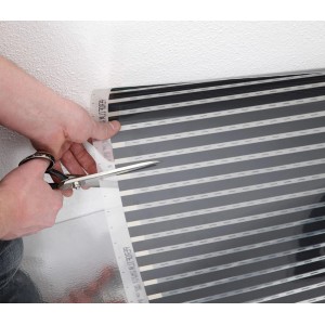 Zuschneiden der Heizfolie für Fußbodentemperierung mit Schere.