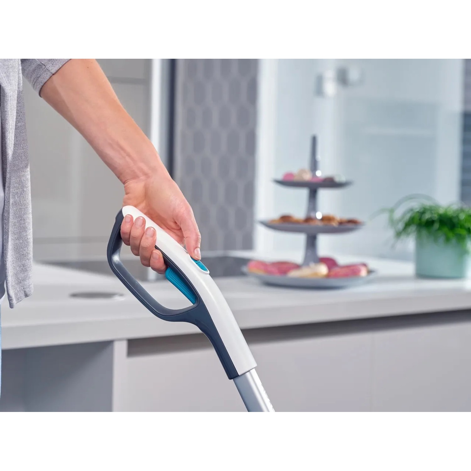Hand hält Leifheit Akku-Saugwischer Regulus Aqua PowerVac im Einsatz.