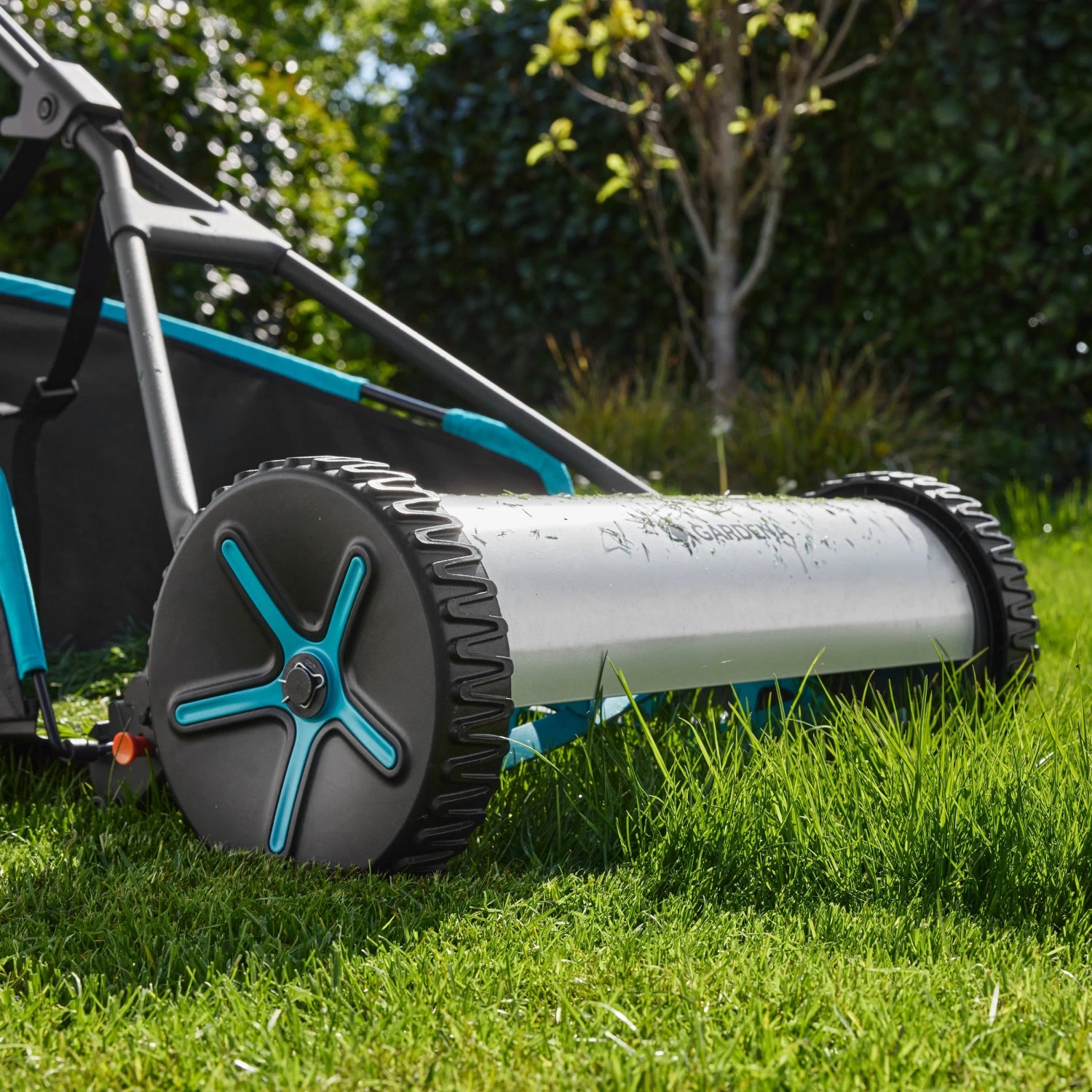 Gardena Spindelmäher Plus 400 mit Fangkorb im Detail auf Rasenfläche.