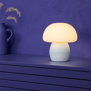 Brilliant LED-Tischleuchte Dupos 22cm Weiß in Pilzform, leuchtet warmweiß auf dunklem Regal. Modern, dimmbar.