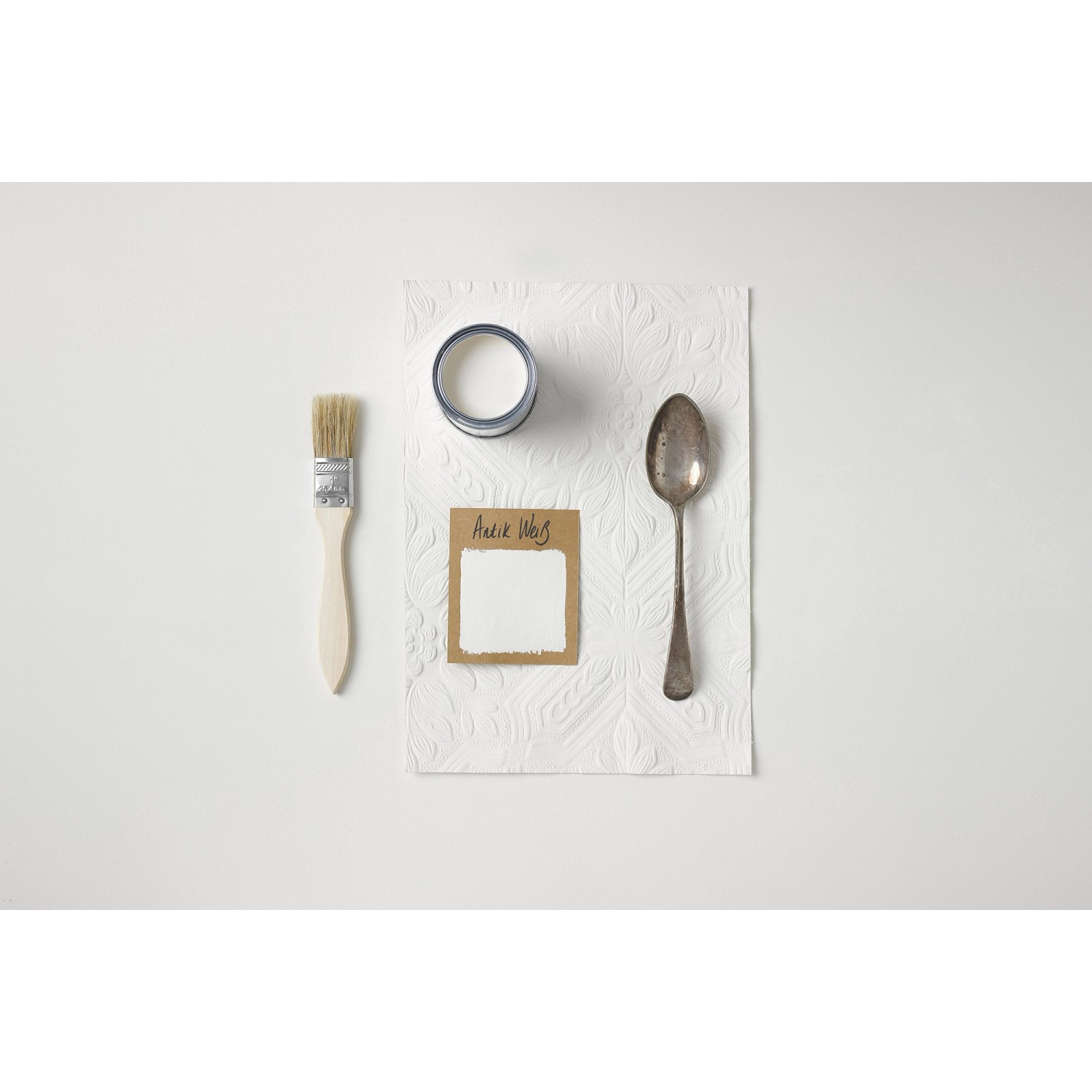 Rust-Oleum Kreidefarbe Antikweiß, 750ml Dose mit Pinsel und Löffel auf weißem Untergrund.