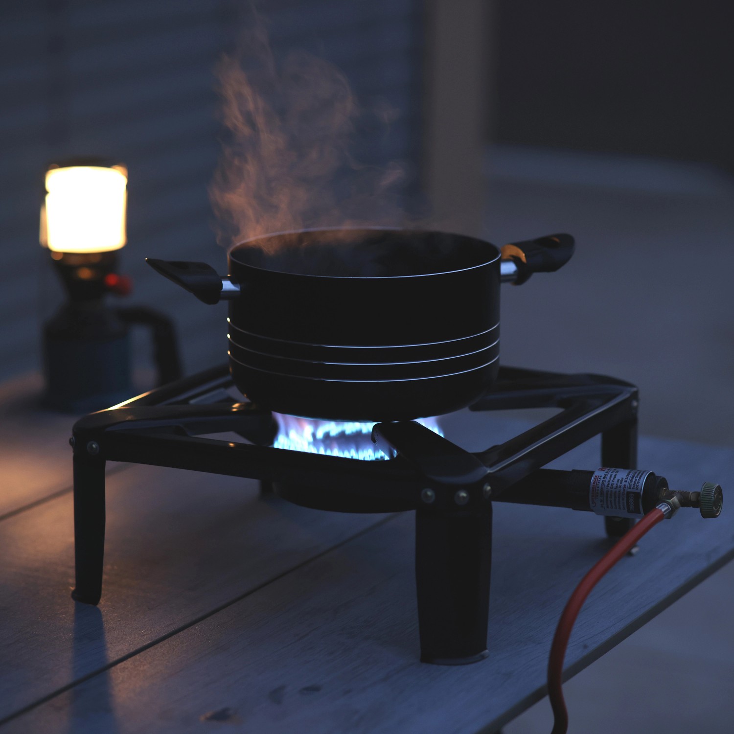 Rothenberger Hockerkocher 7,5 kW mit Topf beim Camping. Gusseisenbrenner mit blauer Flamme.