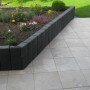Anthrazitfarbene Diephaus Rechteck-Palisade als Beeteinfassung und seitliche Begrenzung im Garten.