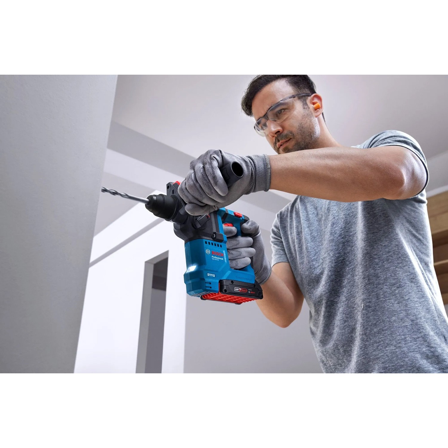 Mann bohrt mit Bosch Akku-Bohrhammer GBH 18V-18. Teil des 18V Akku-Geräte Sets.