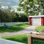 Palmako Holzgarage Rasmus mit Sektionaltor in naturbelassenem Holz, eingebettet in eine Gartenlandschaft.