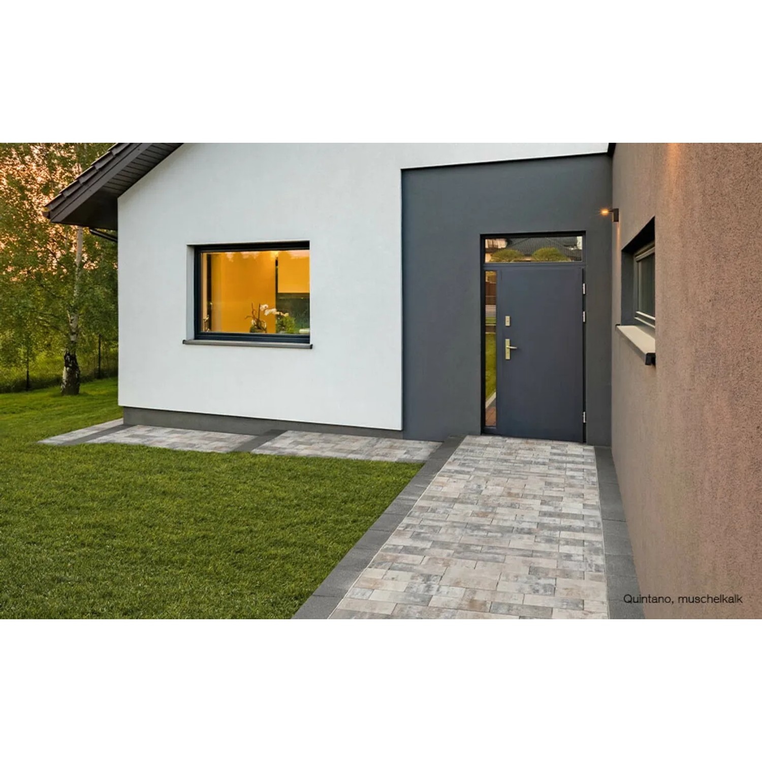 EHL Pflastersteine Veria Muschelcreme, 20x30x8 cm, verlegt als Gehweg vor einem modernen Haus.