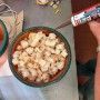 Hand hält braune Soudal Fix All Flexi Dichtstoff-Kartusche über Holzspänen. Vielseitiger Kleber für Silikon & Acryl.