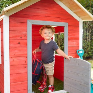 Kind im roten Home Deluxe Spielhaus ''Das kleine Schloss'' aus FSC-Holz.