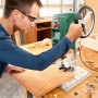 Mann bohrt mit Bosch PBD 40 Tischbohrmaschine ein Holzbrett. Präzises Bohren mit Laser.
