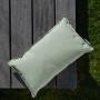 Lindgrünes mokebo Outdoor Kissen 'Das Ruhepolster' 50x30 cm auf Gartentisch.