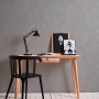 Graue Uni-Tapete von PROFHOME an Wand hinter Schreibtisch mit Lampe und Deko.