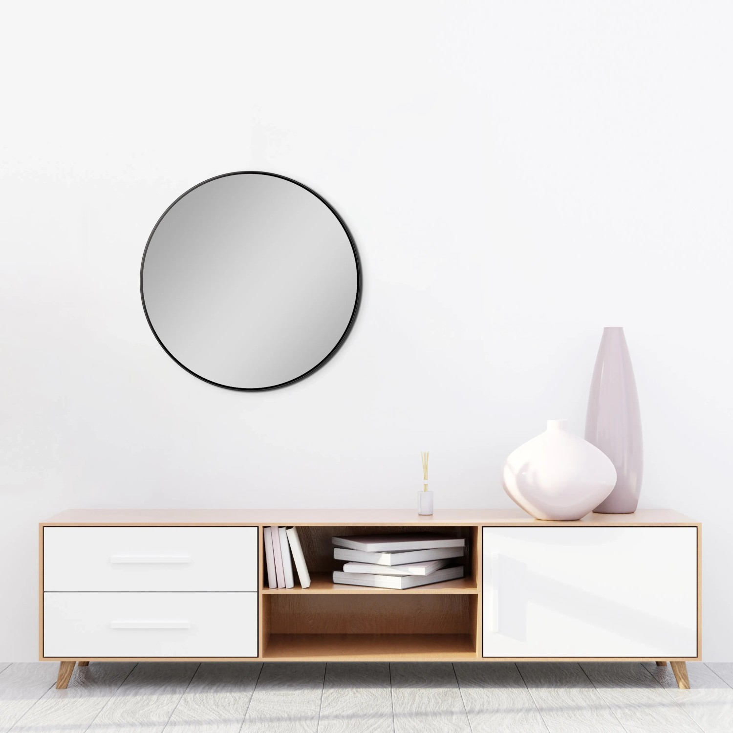 Runder DSK Designspiegel Picasso, Ø 60 cm, mit schwarzem Rahmen an der Wand über einem Sideboard.