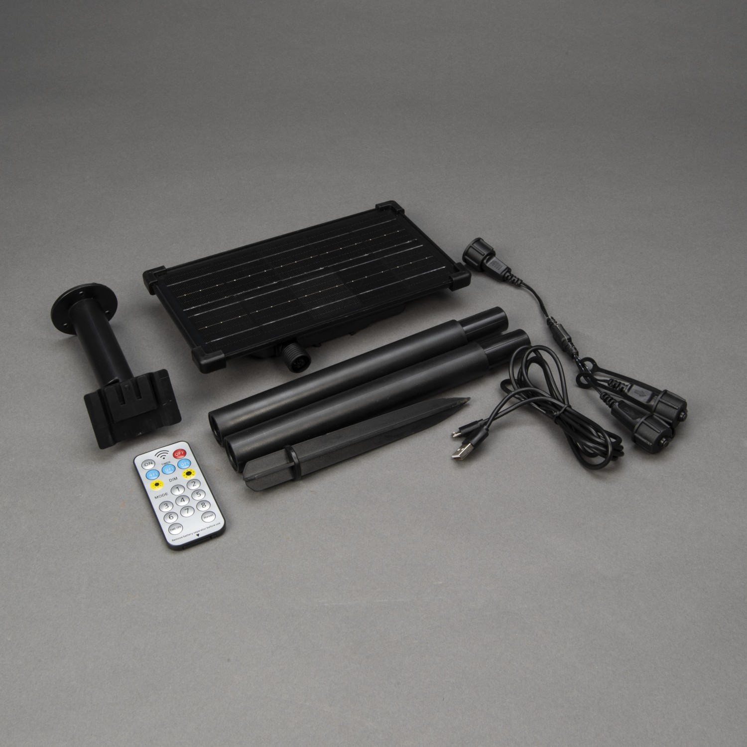 Konstsmide Solar-Batteriebox mit Zubehör: Solarpanel, Fernbedienung, Kabel und Erdspieß für Außen-Lichterketten.